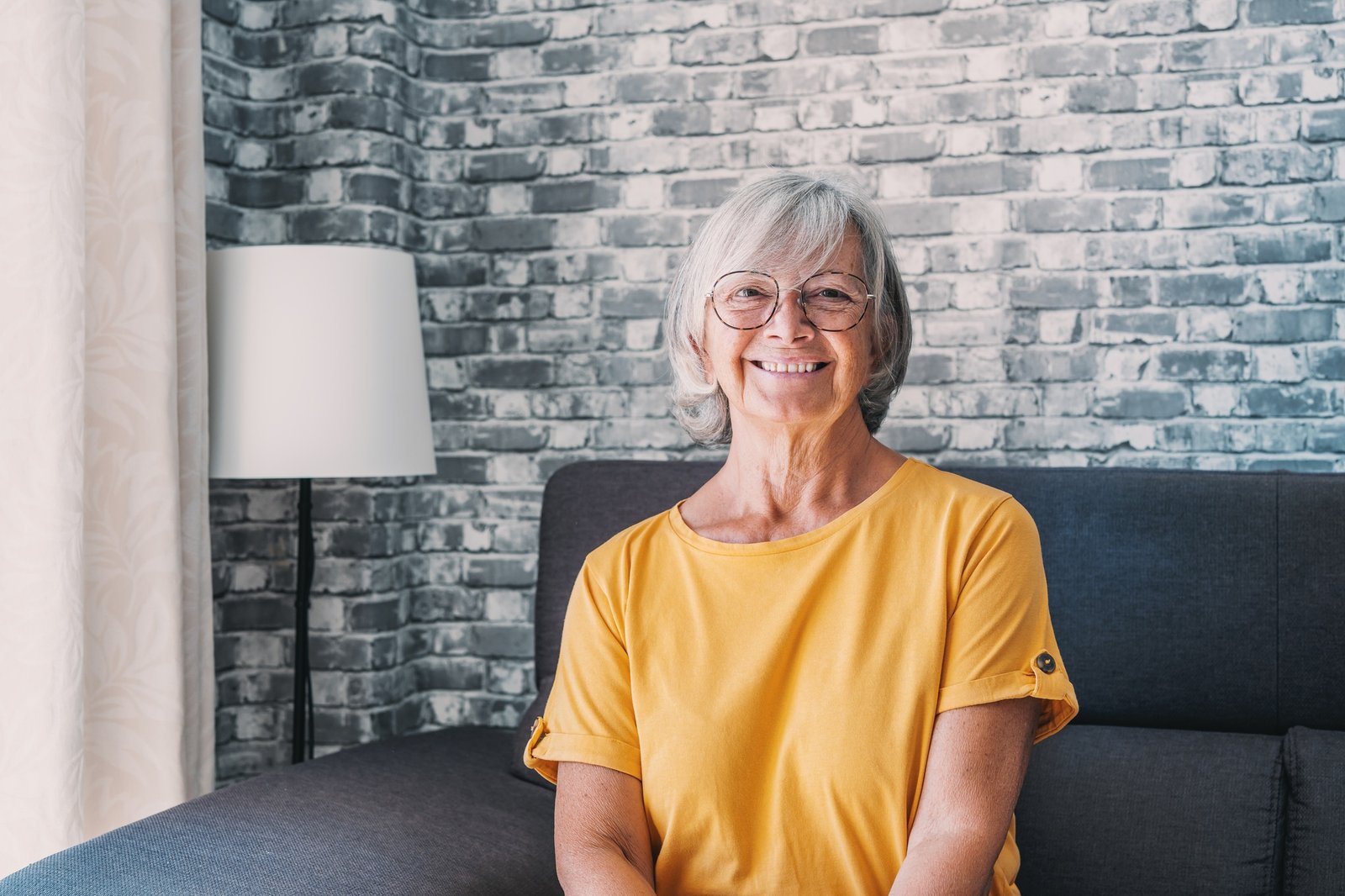 Smiling middle aged mature grey haired woman looking at camera, happy old lady