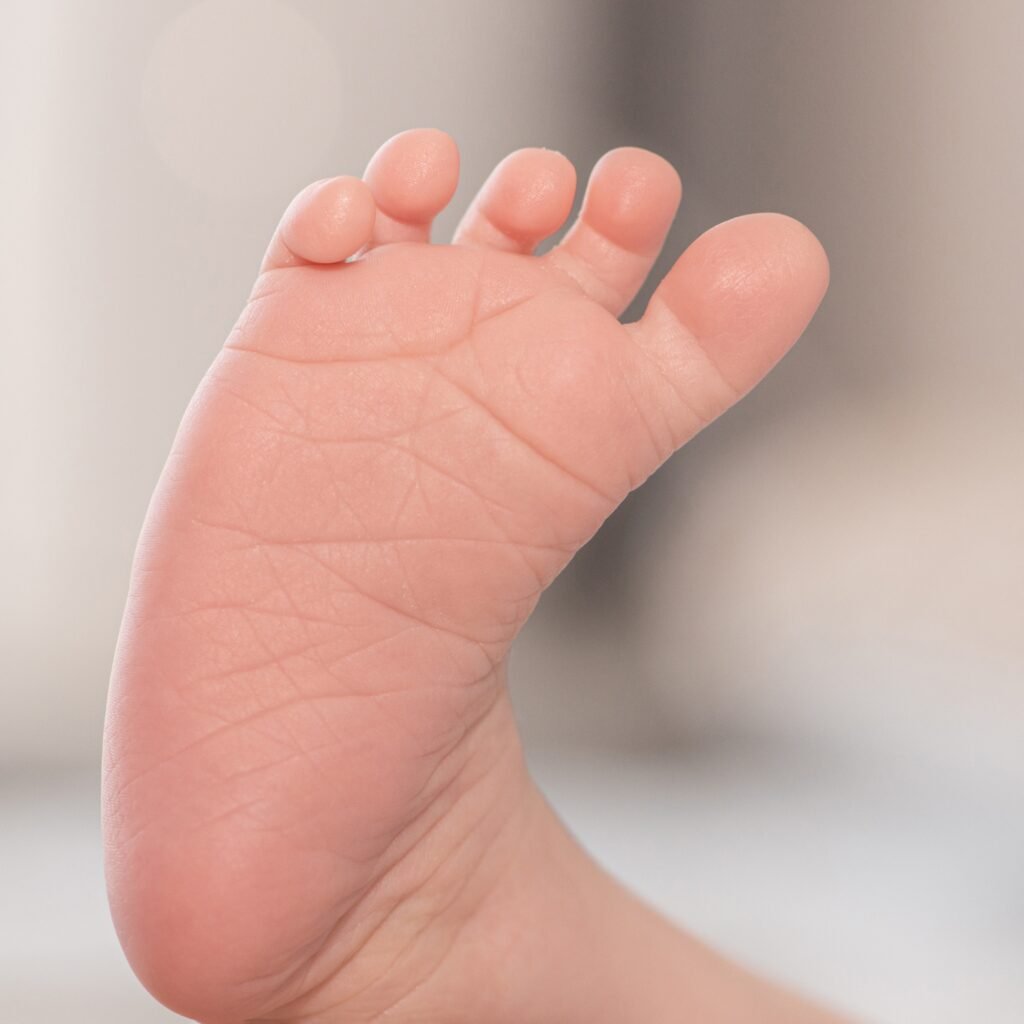 Close-up of baby toes of a newborn baby. The little leg of a white baby.