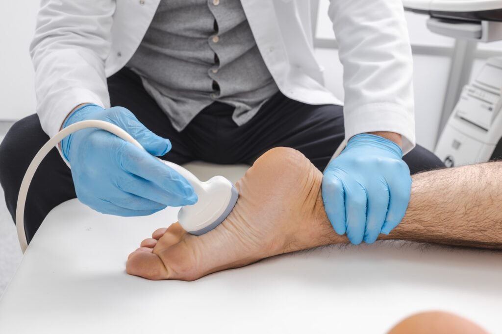 Close-up of injured foot during ultrasound scan with ultrasonic sensor of male sonographer in